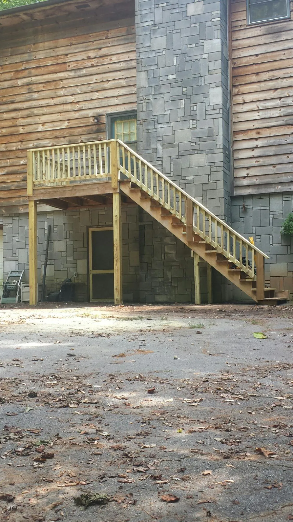 New pressure treated deck and stair landing on a log home in Charlotte