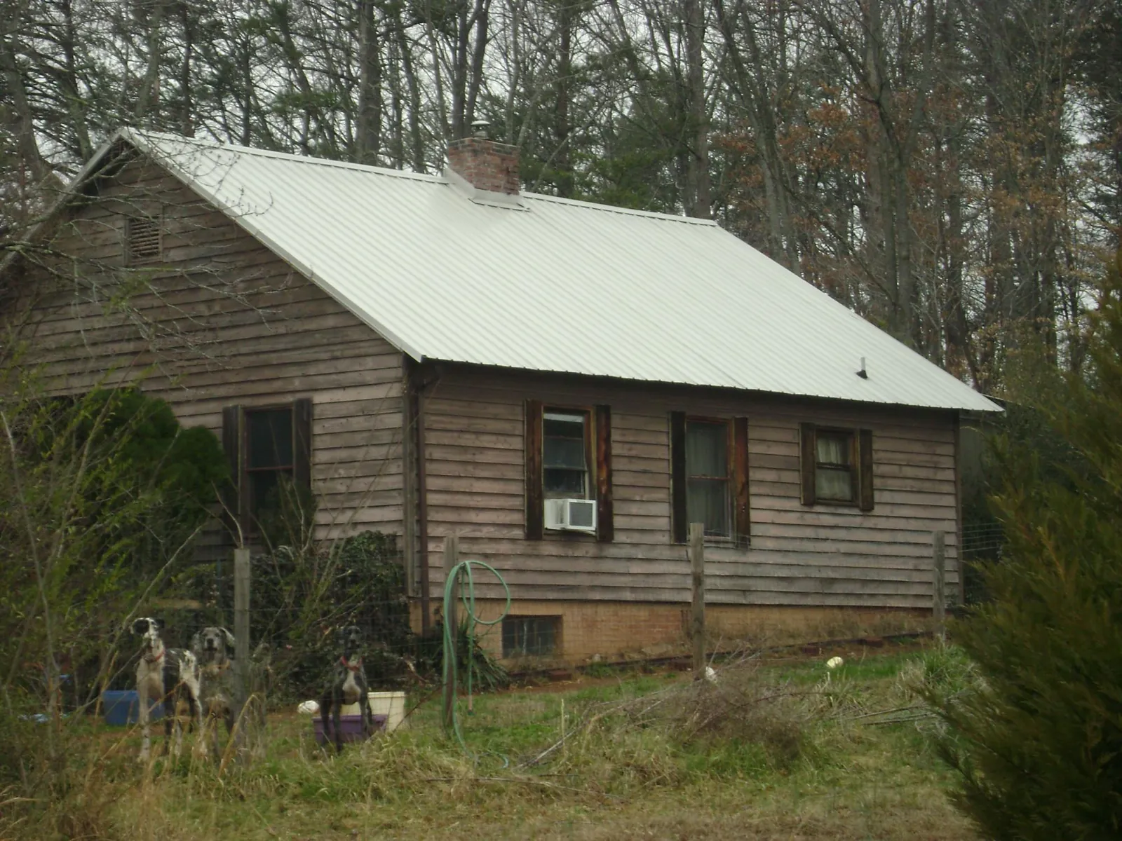 White metal roof on an old wood sided farmhouse, from a Asphalt Shingle Roof Repair job in Charlotte
